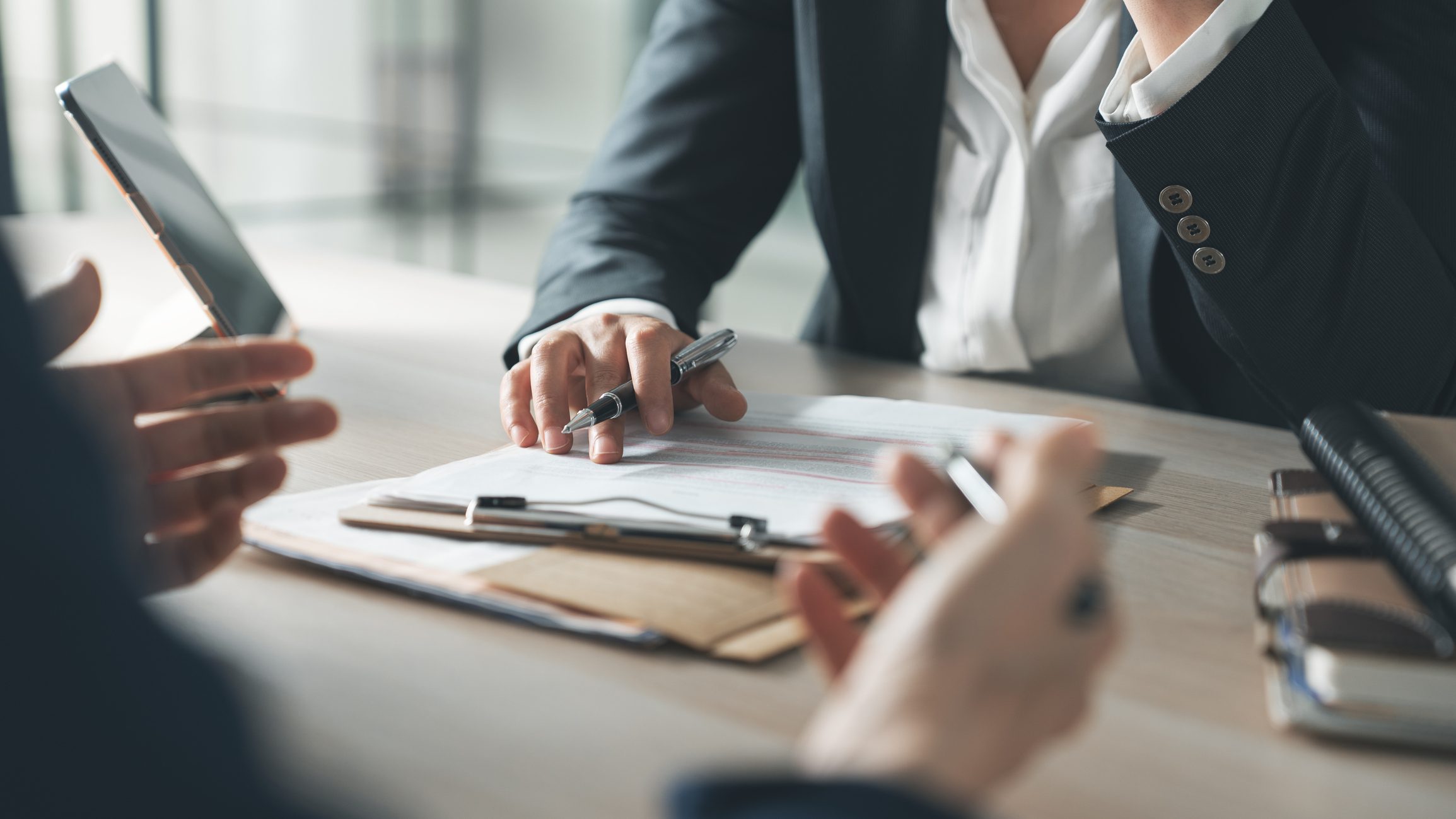 Two professionals reviewing documents during a business meeting.