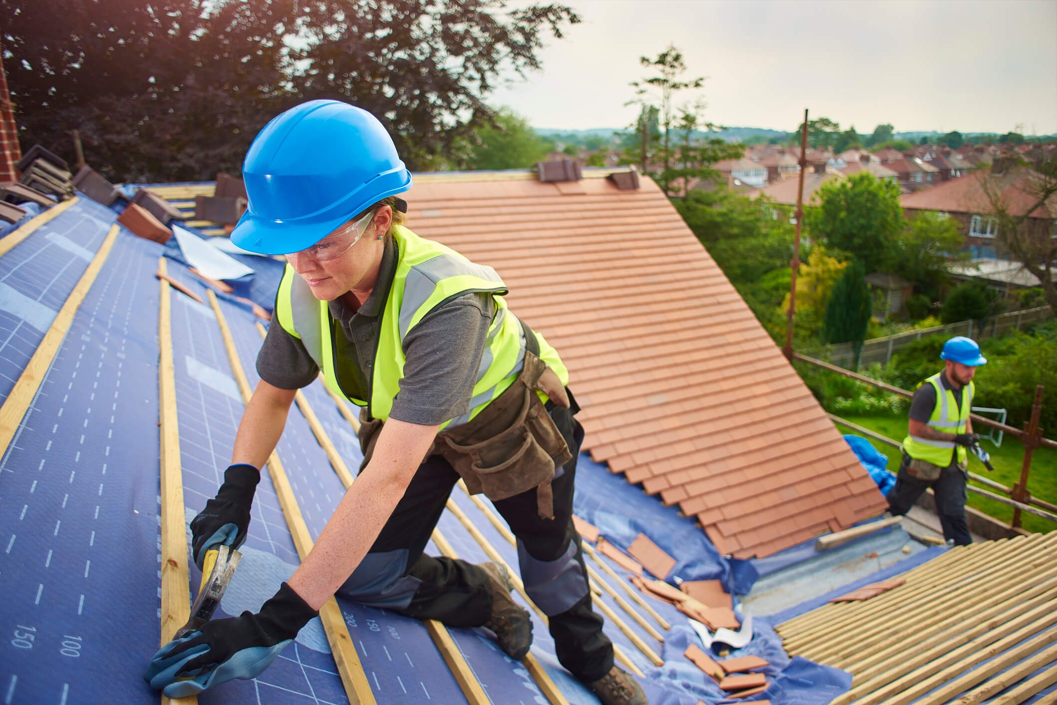 Workers in safety gear on rooftop