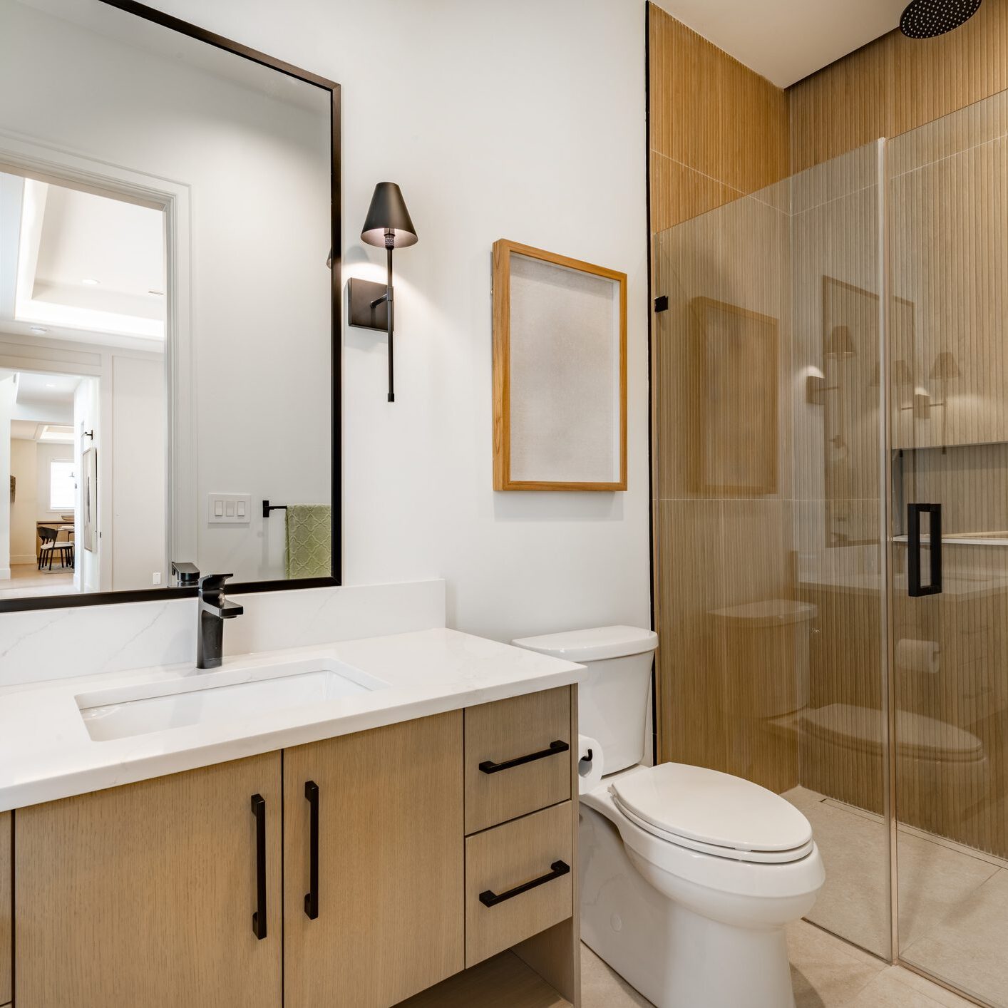 Modern bathroom with wooden cabinets and glass shower enclosure.